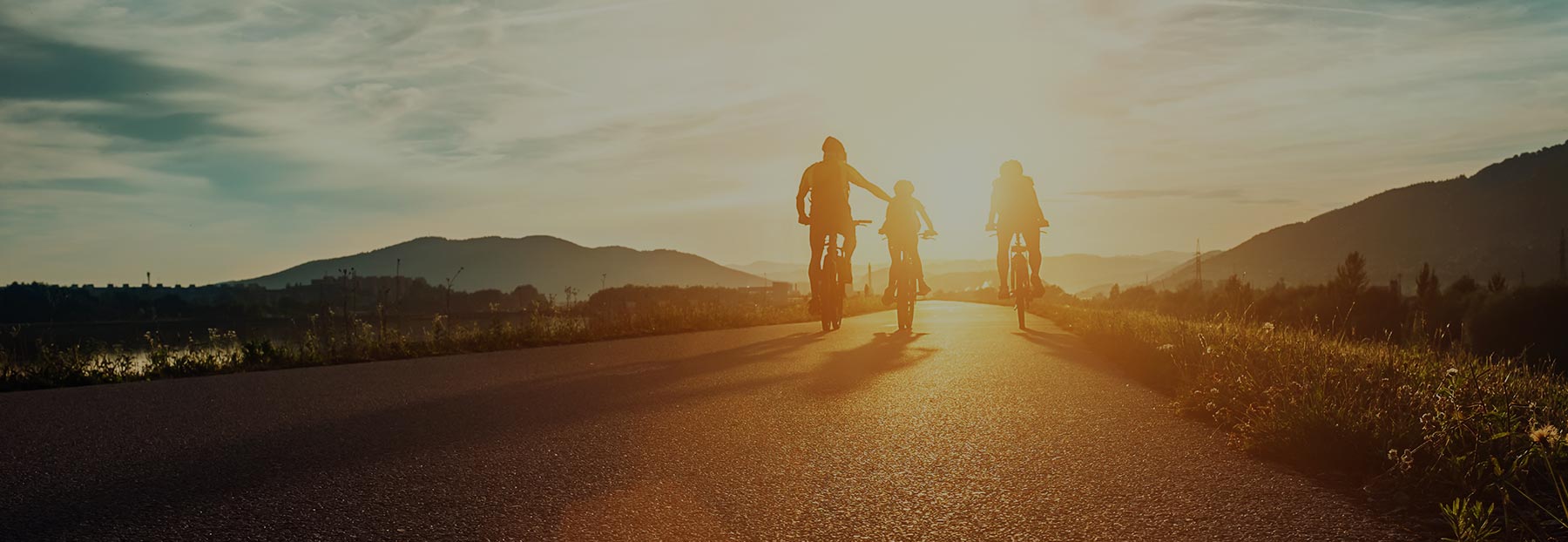 Family of bicyclists at sunset