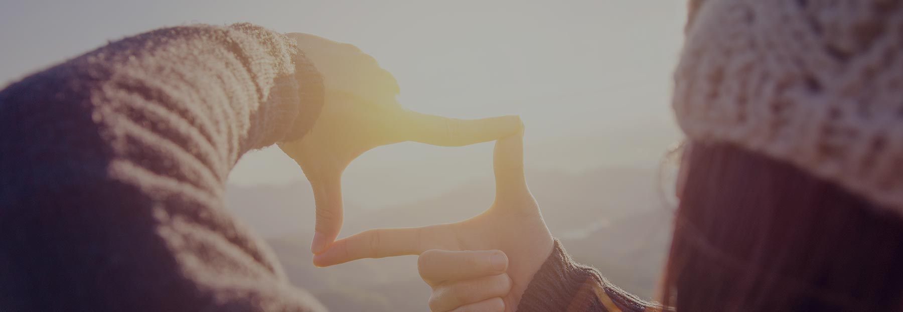 close up of a woman looking through fingers during hike