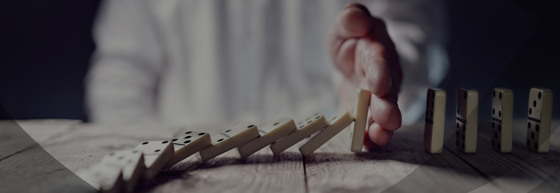 Close up of man stopping the cascade of dominos from falling