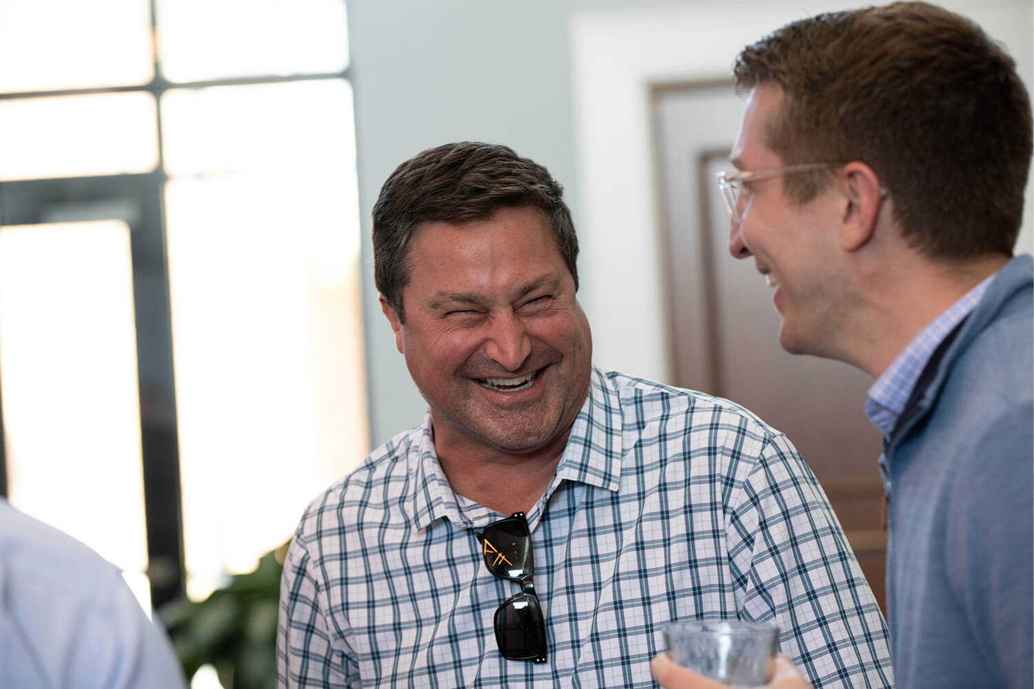 Two men sharing a laugh in a bright, welcoming community space.