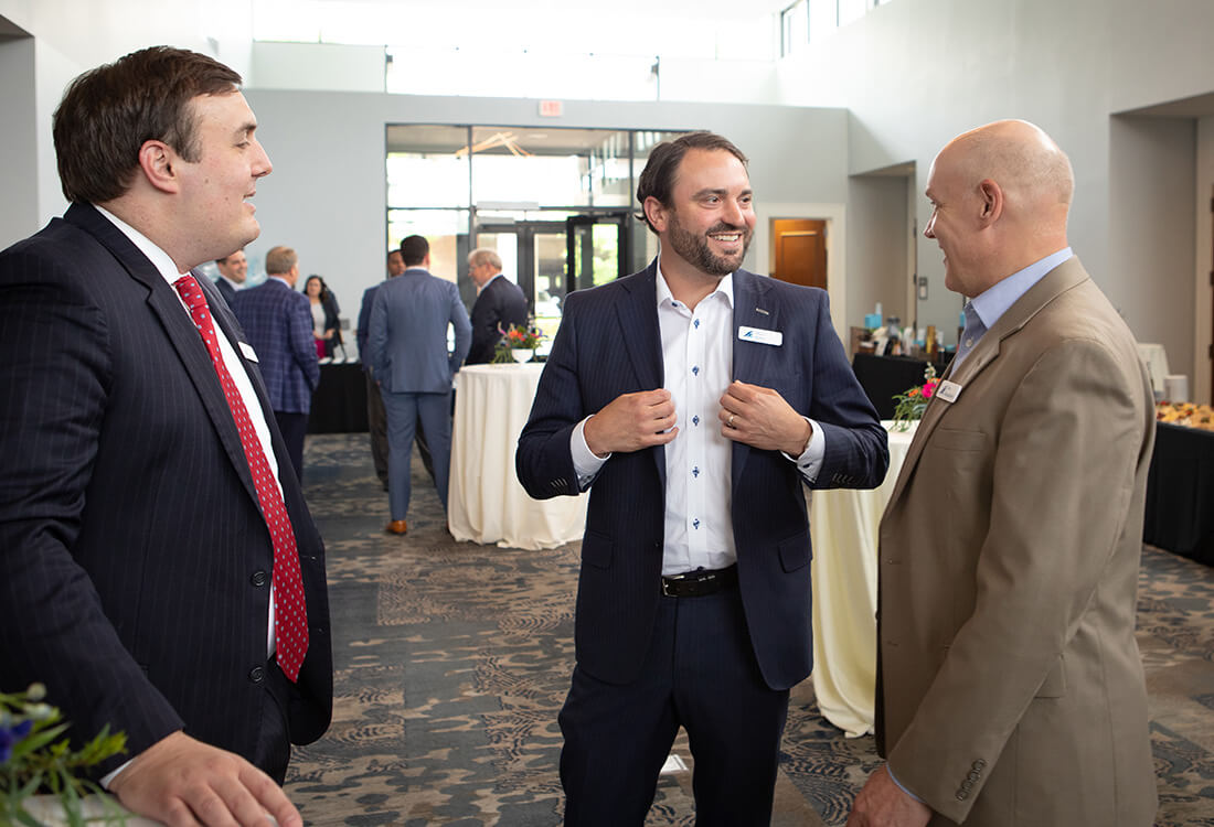 Hamilton Capital team conversing at a market review conference.